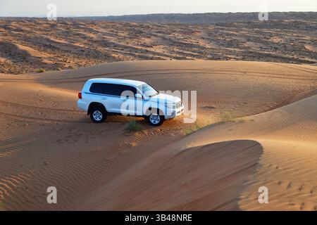 RUB Al Khali Wüste, Sultanat Oman - 6. April 2025: Geländewagen in der Wüste Wahiba Sands bei Sonnenaufgang, Arabische Halbinsel Stockfoto