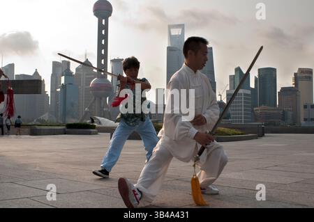 26. Juli 2014 - Shanghai, China - Tai-Chi-Übungen am frühen Morgen mit Schwertern auf dem Bund in Shanghai China. Der beste Taichi-Unterricht, den ich je hatte, war von einem alten Kerl, der jeden Morgen um 7 Uhr draußen übte. Ich habe 4 hervorragende Techniken gelernt, die ich immer noch regelmäßig in meinem MMA-Training verwende: Eine Methode, um einen Kick zu fangen und den Gegner zu werfen, einen geraden Schlag umzulenken und in derselben Bewegung zu kontern, doppelte Unterhaken mit einem Wurf zu kontern und einem Schulterverschluss zu entgehen, während ich deine eigene aufbaue. (Bild: © Sergi Reboredo/ZUMA Wire/ZUMAPRESS.com) Stockfoto