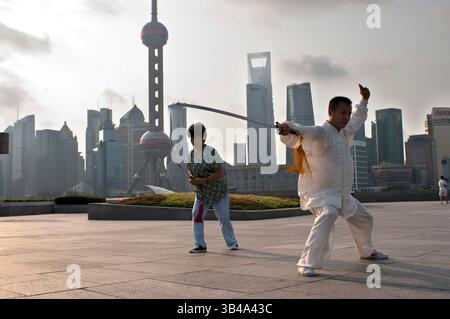 26. Juli 2014 - Shanghai, China - Tai-Chi-Übungen am frühen Morgen mit Schwertern auf dem Bund in Shanghai China. Der beste Taichi-Unterricht, den ich je hatte, war von einem alten Kerl, der jeden Morgen um 7 Uhr draußen übte. Ich habe 4 hervorragende Techniken gelernt, die ich immer noch regelmäßig in meinem MMA-Training verwende: Eine Methode, um einen Kick zu fangen und den Gegner zu werfen, einen geraden Schlag umzulenken und in derselben Bewegung zu kontern, doppelte Unterhaken mit einem Wurf zu kontern und einem Schulterverschluss zu entgehen, während ich deine eigene aufbaue. (Bild: © Sergi Reboredo/ZUMA Wire/ZUMAPRESS.com) Stockfoto