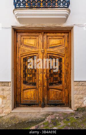 Eine wunderschön gefertigte Holztür mit kunstvollen schmiedeeisernen Paneelen in der historischen Stadt Segorbe, Spanien, die traditionelles spanisches Design zeigt Stockfoto