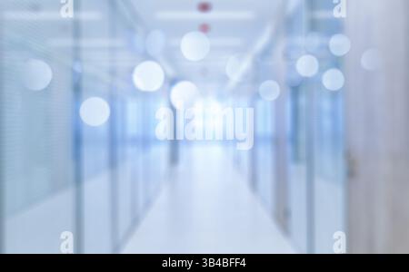Verschwommener Hintergrund eines modernen Büros mit Glaswänden und einem Tisch im Vordergrund. In einer modernen Büroumgebung, verschwimmt der Hintergrund Stockfoto