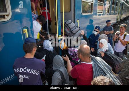 14. September 2015: Flüchtlinge sahen, wie sie in den Zug stürzten, der sie in Richtung Österreich bringen wird. - Die ungarischen Behörden waren auf Züge angewiesen, um Flüchtlinge von der Ungarisch-serbischen Grenze nach Österreich zu transportieren, da sie die Grenze zu Serbien innerhalb der nächsten Stunden schließen wollten. 14. September 2015. (Kreditbild: © Geovien so via ZUMA Wire) Stockfoto