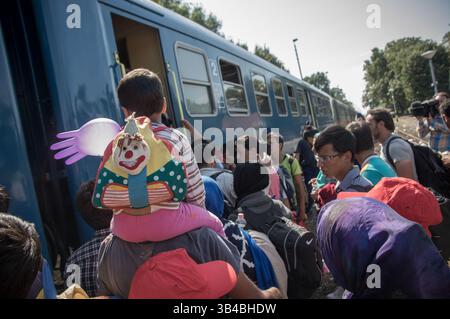 14. September 2015: Flüchtlinge sahen, wie sie in den Zug stürzten, der sie in Richtung Österreich bringen wird. - Die ungarischen Behörden waren auf Züge angewiesen, um Flüchtlinge von der Ungarisch-serbischen Grenze nach Österreich zu transportieren, da sie die Grenze zu Serbien innerhalb der nächsten Stunden schließen wollten. 14. September 2015. (Kreditbild: © Geovien so via ZUMA Wire) Stockfoto