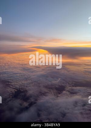 Ein farbenfroher Sonnenuntergang über den Wolken, aufgenommen von einem Jet-Flugzeug über Florida. Stockfoto