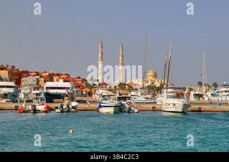 Boote und Yachten im Yachthafen Hurghada mit Minaretten der El Mina Moschee und Kuppel im Hintergrund, Küstenresort am Roten Meer und islamische Architektur, Ägypten. Stockfoto