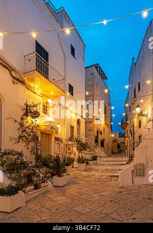 Schmale Straße in Ostuni, nachts von Straßenlaternen beleuchtet, Apulien - Apulien, Italien Stockfoto