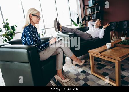 Leitende Geschäftsleute in einer gemeinsamen Bürotagungsumgebung mit modernem Innendesign, Interaktion und Teamwork Stockfoto
