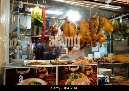 Traditionelles kantonesisches Bratfleisch, das im Fenster des Restaurants hängt, einschließlich ganzer Enten und Würstchen. Stockfoto