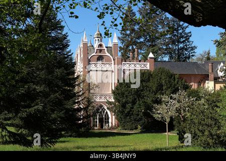 Neogotisches Gebäude, umgeben von Grün im Frühling. Stockfoto