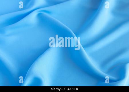 Glatter und fließender blauer Seidenhintergrund für elegante Designs Stockfoto