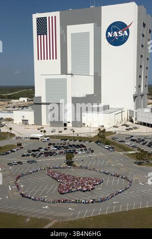 21. März 2011 – Cape Canaveral, Florida, USA – Tausende von Mitarbeitern des Kennedy Space Center der NASA stehen Seite an Seite, um eine vollständige Umrisse eines Space Shuttle-Orbiters vor dem Fahrzeugmontagegebäude zu bilden. Die einzigartige Fotogelegenheit wurde entworfen, um das 30-jährige Erbe des Space Shuttle Programms und die Menschen zu ehren, die zur sicheren Verarbeitung, zum Start und zur Landung des Fahrzeugs beitragen. (Bild: © Kim Shiflett/NASA/ZUMAPRESS.com) Stockfoto