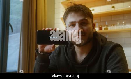 Junger Mann, der ein Smartphone hält, zeigt die Nachricht „Ich bin nicht KI“ an, um die menschliche Identität in einer digitalen Welt hervorzuheben Stockfoto