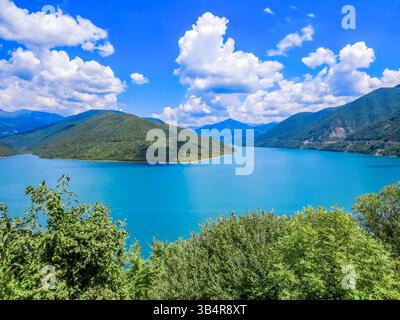 Panorama des Zhinvali Reservoir mit türkisfarbenem Wasser, umgeben von malerischen Kaukasus Bergen auf der Georgian Military Road. Wasserkraftdamm auf der ARAG Stockfoto