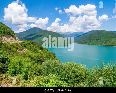 Panorama des Zhinvali Reservoir mit türkisfarbenem Wasser, umgeben von malerischen Kaukasus Bergen auf der Georgian Military Road. Wasserkraftdamm auf der ARAG Stockfoto