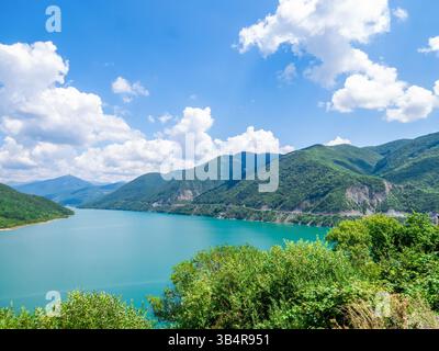 Panorama des Zhinvali Reservoir mit türkisfarbenem Wasser, umgeben von malerischen Kaukasus Bergen auf der Georgian Military Road. Wasserkraftdamm auf der ARAG Stockfoto