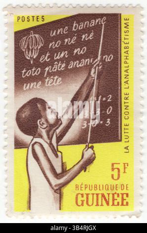 GUINEA - 19. September 1962: 5 Franken gelbe, dunkelbraune und orangene Briefmarke mit der Darstellung des Kindes an der Blackboard. Kampagne gegen Analphabetentum. Alphabetisierung im weitesten Sinne beschreibt „besondere Arten des Denkens und des Schreibens“ mit dem Ziel, Gedanken oder Ideen in schriftlicher Form in einem bestimmten Verwendungskontext zu verstehen oder auszudrücken. Mit anderen Worten, Menschen in literarischen Gesellschaften haben eine Reihe von Praktiken, um Schreiben zu produzieren und zu konsumieren, und sie haben auch Überzeugungen über diese Praktiken Stockfoto