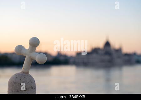Budapest, Ungarn – 22. September 2024: Nationalkreuzsymbol gegen Parlament – das geneigte Kruzifix steht feierlich vor Budapests großem Wahrzeichen Stockfoto