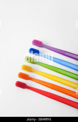 Sechs bunte Zahnbürsten auf weißem Hintergrund. Regenbogen. Platz für Text. Ritual. Mundhygiene. Kinder Stockfoto