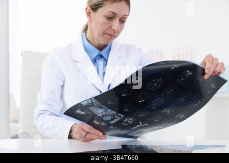 Arzt untersucht MRT-Scan am Schreibtisch im Krankenhaus, Nahaufnahme Stockfoto