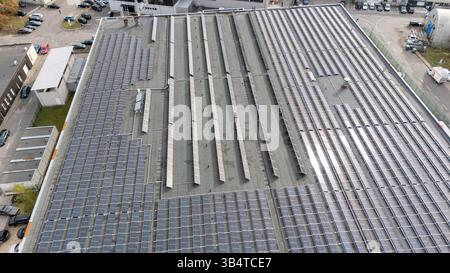 Aus der Vogelperspektive auf einem großen Dach, das mit Solarpaneelen bedeckt ist, auf einem Industriegebäude. Stockfoto
