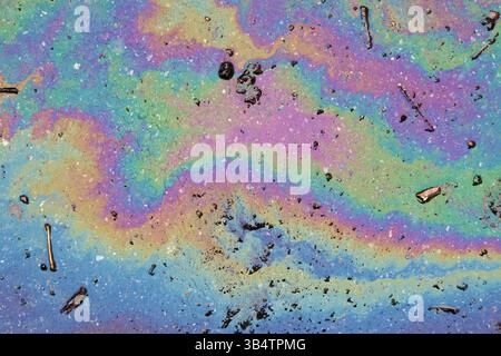 Bild einer Ölpest auf Asphalt. Regenbogenfarben. Stockfoto