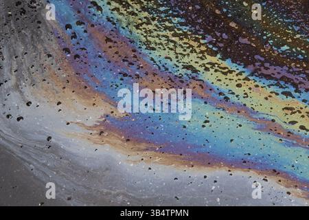 Ölpest auf dem Asphaltstraßenhintergrund. Elegantes Hintergrundbild. Stockfoto