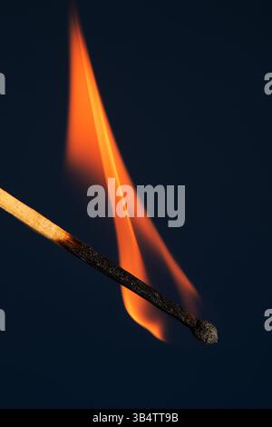 Brennender Match auf blauem Hintergrund. Eine Welle gelber Flammen. Stockfoto
