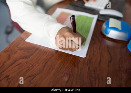 Nahaufnahme der Handschrift auf Steuerformular am Holztisch Stockfoto