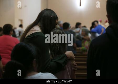 25. Mai 2022, Uvalde, Texas, USA: People Hug at the Start of a Mass for Opfers of the Robb Elementary School Shooting in Sacred Heart Church in Uvalde, Texas, Mittwoch, 25. Mai 2022. (Foto: © Jerry Lara/San Antonio Express-News via ZUMA Press Wire) Stockfoto