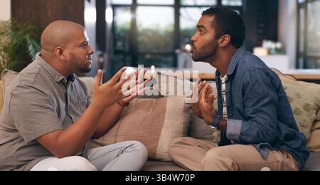 Männer, schwule Paare und Streit auf dem Sofa zu Hause mit Diskussionen, Meinungsverschiedenheiten und Beziehungskonflikten. Wütende, queere Leute und kämpfen mit Scheidung Stockfoto