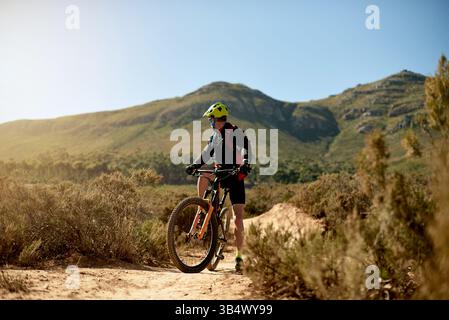 Radfahren, Fitness und Fahrten auf unbefestigten Straßen für Schotterrennen, Challenge oder Wettkampftraining. Sport, Mountainbike und Radsportler fahren weiter Stockfoto