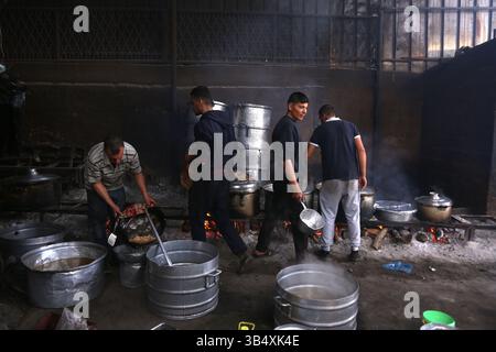 23. April 2022, Rafah, Gazastreifen, Palästina: Palästinenser kochen über Feuer. Suleiman Al-Aloul Madi verwendet seit 50 Jahren Feuer, um Speisen zu kochen, während er Mahlzeiten nach den Wünschen des Kunden zubereitet. Dies hilft ihm auch, die schwierigen Bedingungen im Gazastreifen zu überwinden. (Bild: © Samar Abu Elouf/ZUMA Press Wire Service) Stockfoto