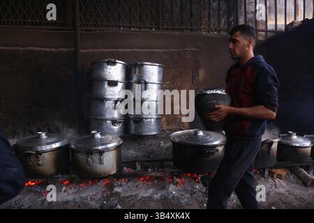 23. April 2022, Rafah, Gazastreifen, Palästina: Palästinenser kochen über Feuer. Suleiman Al-Aloul Madi verwendet seit 50 Jahren Feuer, um Speisen zu kochen, während er Mahlzeiten nach den Wünschen des Kunden zubereitet. Dies hilft ihm auch, die schwierigen Bedingungen im Gazastreifen zu überwinden. (Bild: © Samar Abu Elouf/ZUMA Press Wire Service) Stockfoto