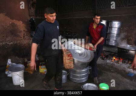 23. April 2022, Rafah, Gazastreifen, Palästina: Palästinenser kochen über Feuer. Suleiman Al-Aloul Madi verwendet seit 50 Jahren Feuer, um Speisen zu kochen, während er Mahlzeiten nach den Wünschen des Kunden zubereitet. Dies hilft ihm auch, die schwierigen Bedingungen im Gazastreifen zu überwinden. (Bild: © Samar Abu Elouf/ZUMA Press Wire Service) Stockfoto