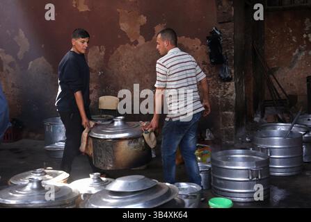 23. April 2022, Rafah, Gazastreifen, Palästina: Palästinenser kochen über Feuer. Suleiman Al-Aloul Madi verwendet seit 50 Jahren Feuer, um Speisen zu kochen, während er Mahlzeiten nach den Wünschen des Kunden zubereitet. Dies hilft ihm auch, die schwierigen Bedingungen im Gazastreifen zu überwinden. (Bild: © Samar Abu Elouf/ZUMA Press Wire Service) Stockfoto