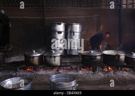 23. April 2022, Rafah, Gazastreifen, Palästina: Palästinenser kochen über Feuer. Suleiman Al-Aloul Madi verwendet seit 50 Jahren Feuer, um Speisen zu kochen, während er Mahlzeiten nach den Wünschen des Kunden zubereitet. Dies hilft ihm auch, die schwierigen Bedingungen im Gazastreifen zu überwinden. (Bild: © Samar Abu Elouf/ZUMA Press Wire Service) Stockfoto