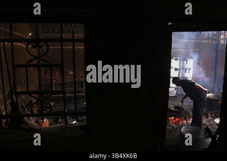 23. April 2022, Rafah, Gazastreifen, Palästina: Palästinenser kochen über Feuer. Suleiman Al-Aloul Madi verwendet seit 50 Jahren Feuer, um Speisen zu kochen, während er Mahlzeiten nach den Wünschen des Kunden zubereitet. Dies hilft ihm auch, die schwierigen Bedingungen im Gazastreifen zu überwinden. (Bild: © Samar Abu Elouf/ZUMA Press Wire Service) Stockfoto
