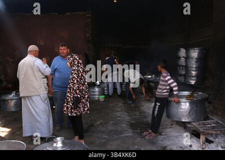 23. April 2022, Rafah, Gazastreifen, Palästina: Palästinenser kochen über Feuer. Suleiman Al-Aloul Madi verwendet seit 50 Jahren Feuer, um Speisen zu kochen, während er Mahlzeiten nach den Wünschen des Kunden zubereitet. Dies hilft ihm auch, die schwierigen Bedingungen im Gazastreifen zu überwinden. (Bild: © Samar Abu Elouf/ZUMA Press Wire Service) Stockfoto