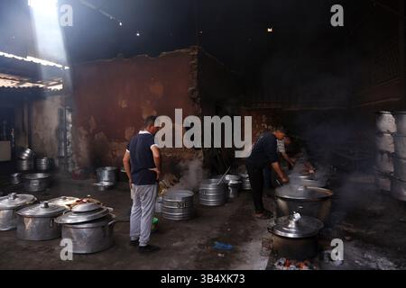 23. April 2022, Rafah, Gazastreifen, Palästina: Palästinenser kochen über Feuer. Suleiman Al-Aloul Madi verwendet seit 50 Jahren Feuer, um Speisen zu kochen, während er Mahlzeiten nach den Wünschen des Kunden zubereitet. Dies hilft ihm auch, die schwierigen Bedingungen im Gazastreifen zu überwinden. (Bild: © Samar Abu Elouf/ZUMA Press Wire Service) Stockfoto