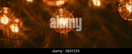 Hintergrund – elektrische Girlande mit Glühlampen, gelbes warmes Licht, Retro-Stil, Sternfilter, stimmungsvolle Nahaufnahme Stockfoto