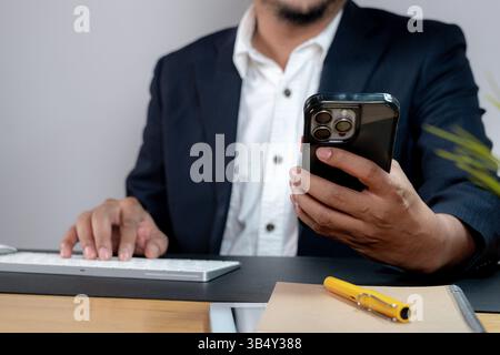 Zugeschnittenes Bild eines Geschäftsmannes, der ein Smartphone hält Stockfoto