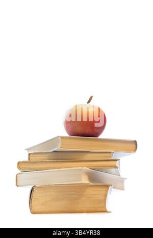 Stapel alter Hardcover-Bücher mit rotem Apfel oben, zentriert auf weißem Hintergrund mit Kopierraum. Toll für Schulbeförderungen, Lehrer-Anerkennung, t Stockfoto