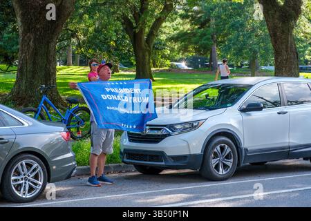 NEW ORLEANS, LA. USA - 24. JUNI 2024: Man ruft Unterstützung für Donald Trump, während er die MAGA-Flagge gegenüber vom Audubon Place hält, wo Trump an einer Spendenaktion teilnimmt Stockfoto