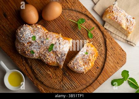 Brioche-Flecht mit gerösteten Mandeln und Puderzucker. Ein traditionelles französisches Gebäckrezept. Stockfoto