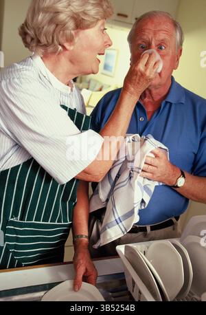 Seniorenpaar waschen Geschirr in der Küche zu Hause. Stockfoto
