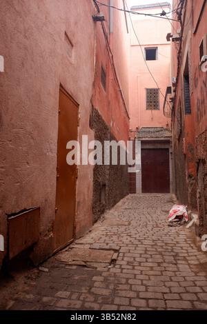 28. Dezember 2024 - Marrakesch, Marokko - Blick auf eine traditionelle enge Passage zwischen Wohn- und Geschäftsgebäuden in der Altstadt von Medin Stockfoto