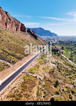 Aus der Vogelperspektive der gewundenen Straße, die sich durch die zerklüftete, bergige Landschaft in der Nähe von Orihuela, Spanien, schlängelt Stockfoto