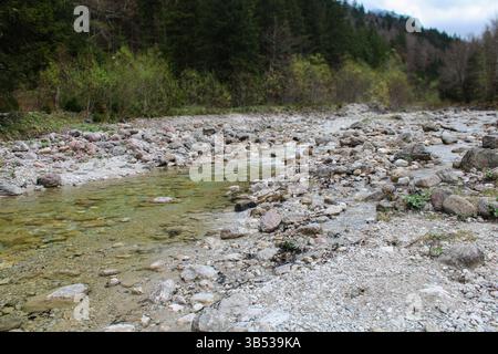 Flacher Fluss mit Steinen und transparentem Wasser in den Alpen Stockfoto