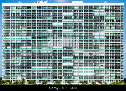 Blick auf ein Wohnhochhaus in Fort Lauderdale mit Rasen und Palmen. Stockfoto