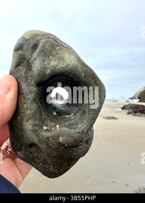 Ein Steinchen - Felsen mit einem natürlichen Loch - am Face Rock Beach in Bandon, Oregon. Stockfoto